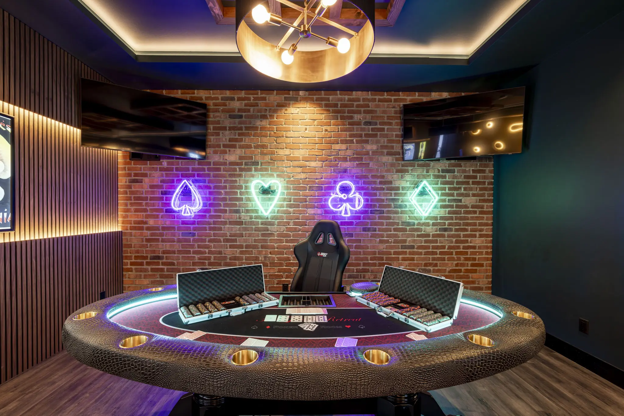poker table under neon poker symbols on wall
